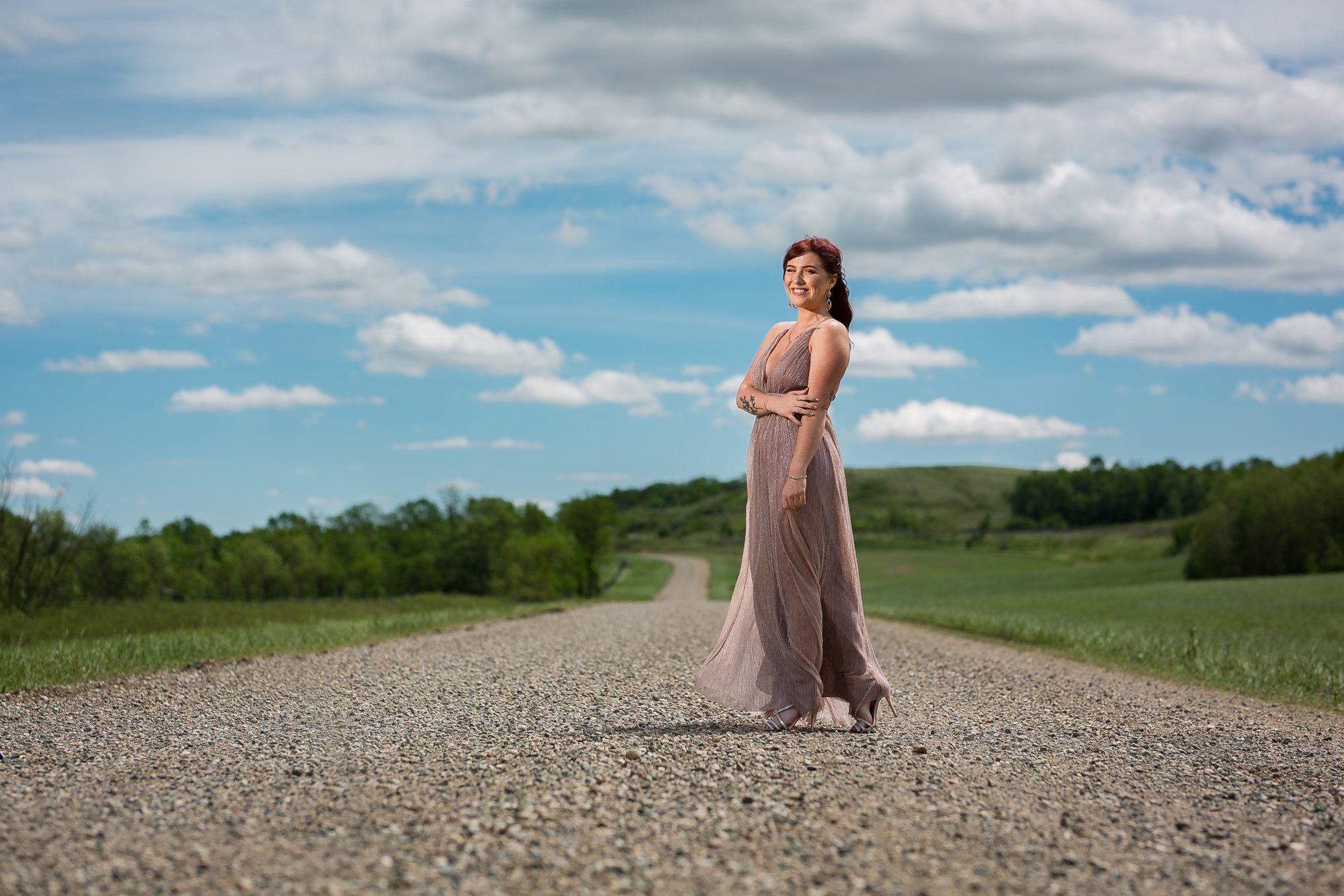 Senior girl in a blush gown on a country road under a big open sky — senior portraits in Michiana