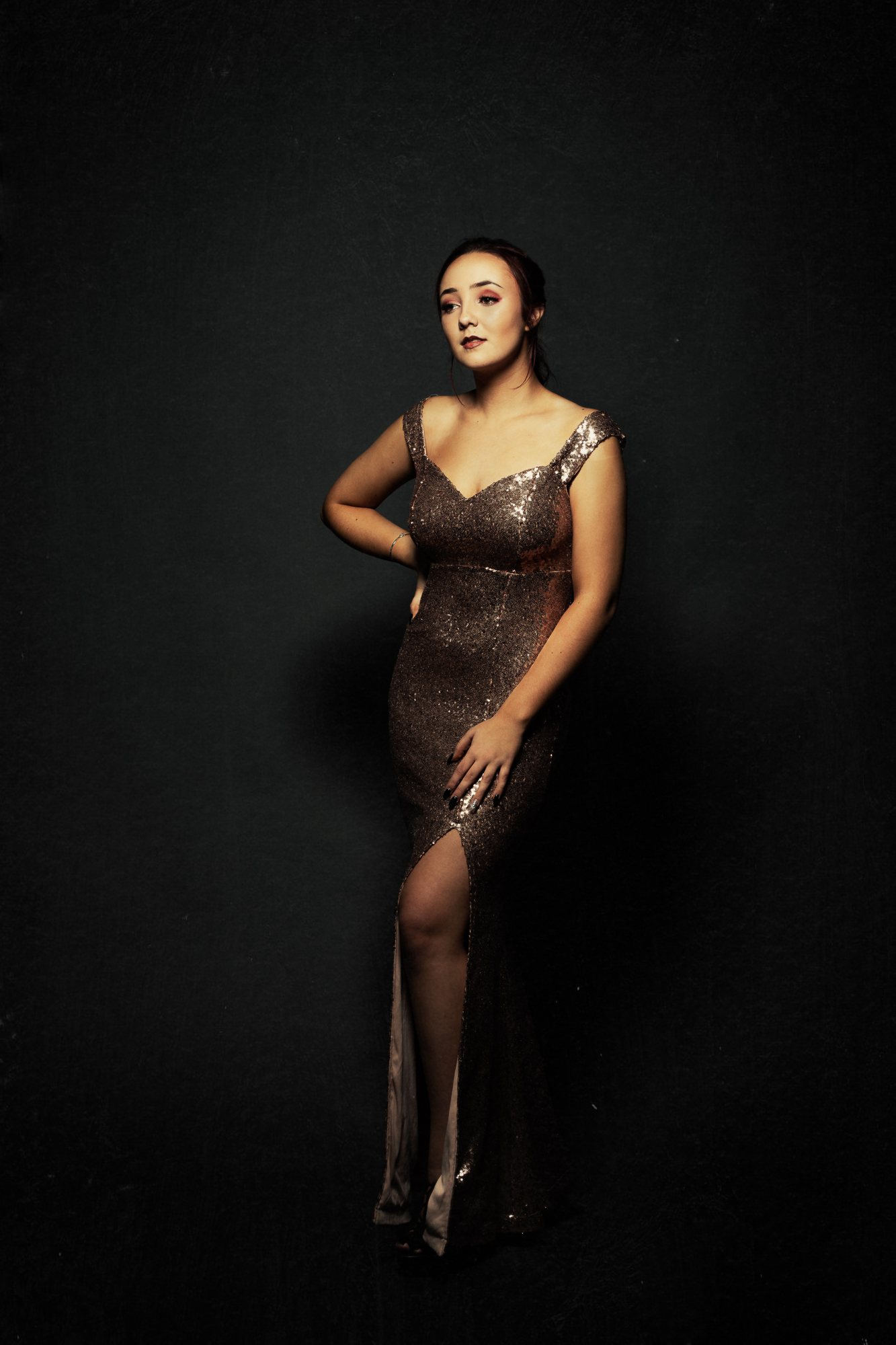 Full-length senior portrait in a bronze gown, posed head to toe in studio