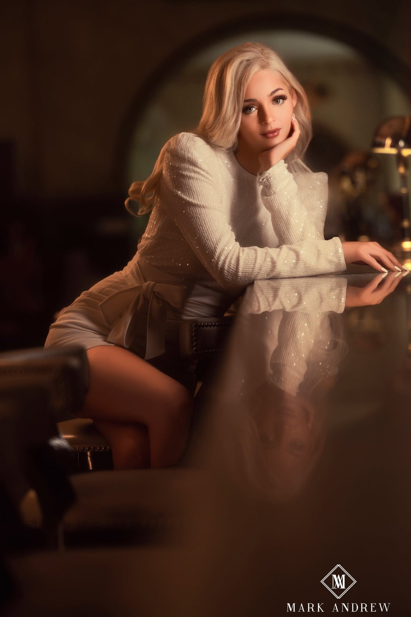 Senior girl in a cream sweater at a grand piano in warm light — senior portraits, South Bend, Indiana