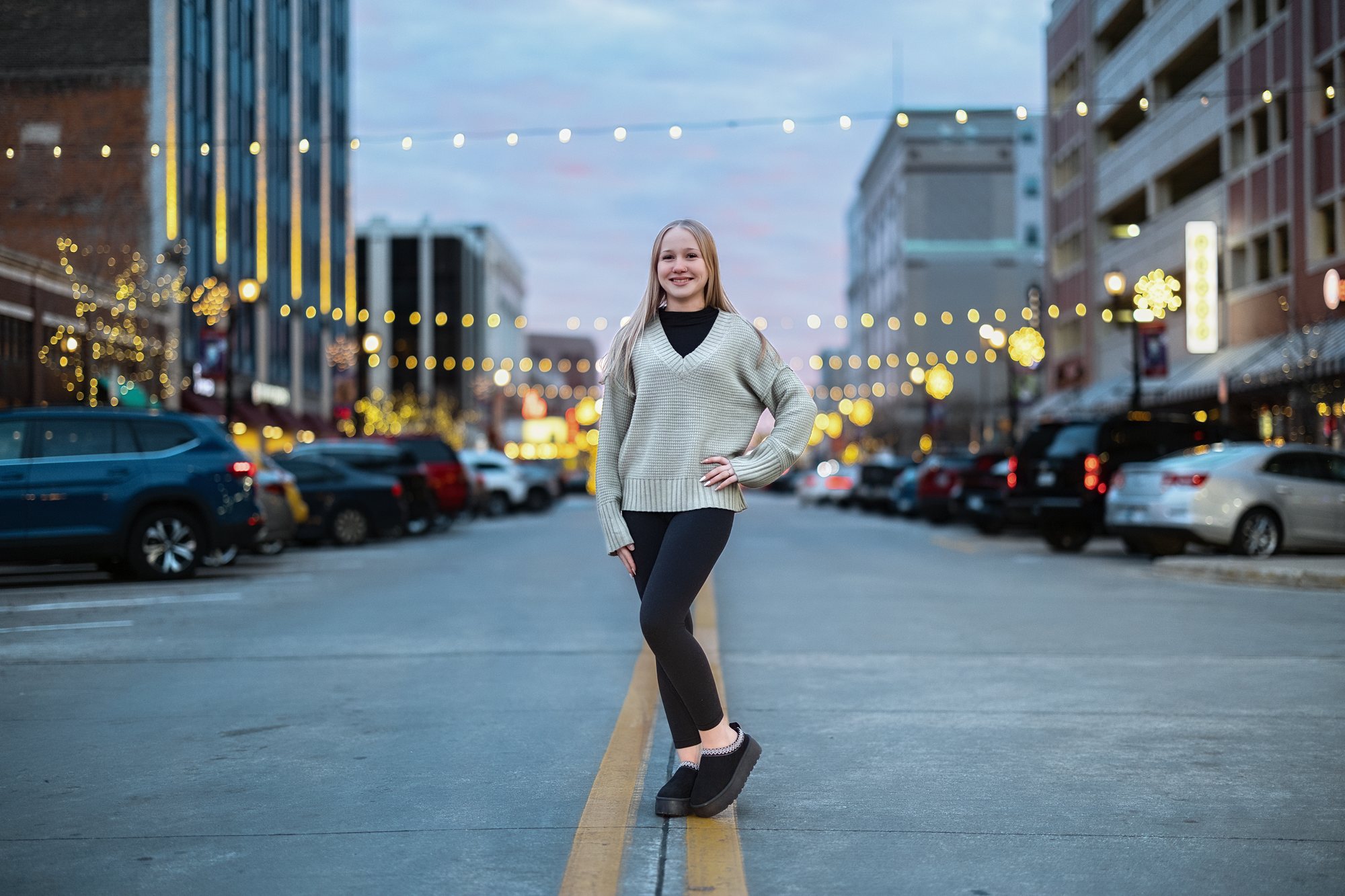Senior girl photographed in a downtown street under string lights — South Bend, Indiana
