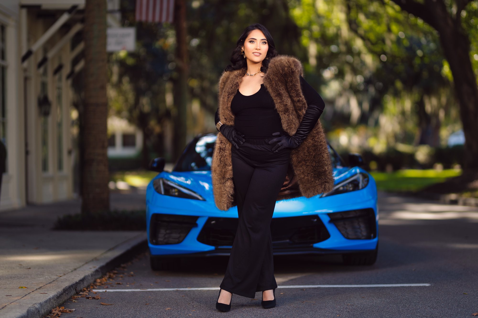 Senior girl in a fur coat beside a blue sports car downtown — senior pictures in South Bend, Indiana