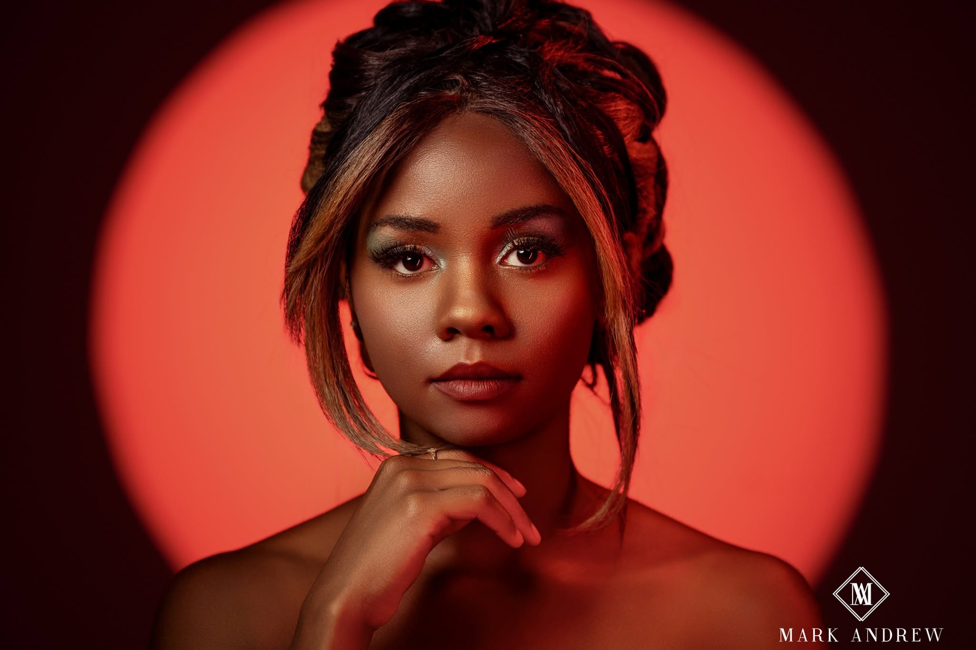 South Bend senior with polished hair and makeup photographed in a dramatic red spotlight