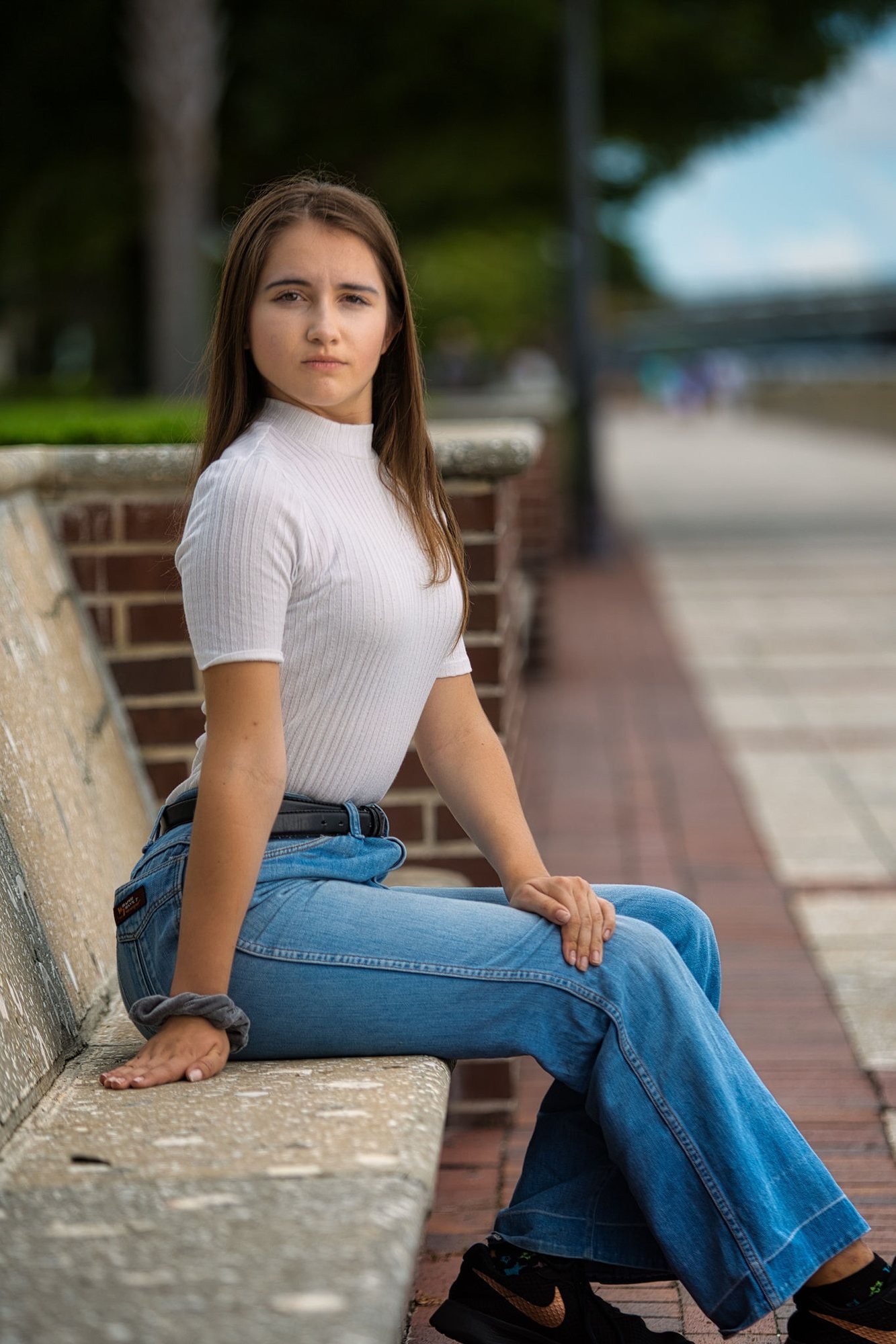 Senior girl in a white tee and jeans on a brick ledge downtown — senior pictures, Mishawaka, Indiana