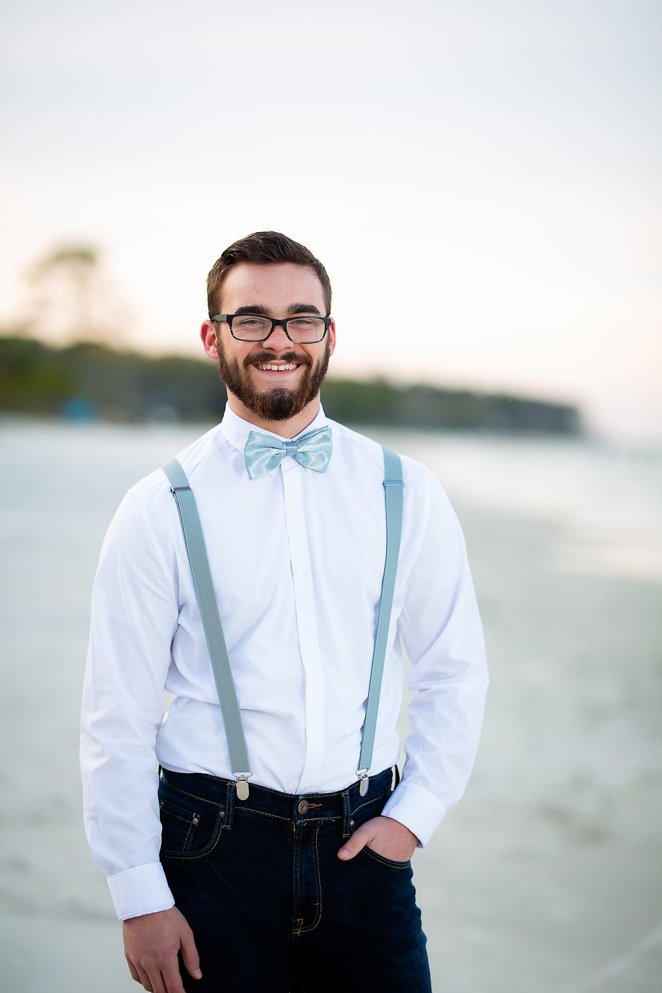 Senior guy in suspenders and a bow tie at the waterfront at golden hour — senior portraits, Michiana